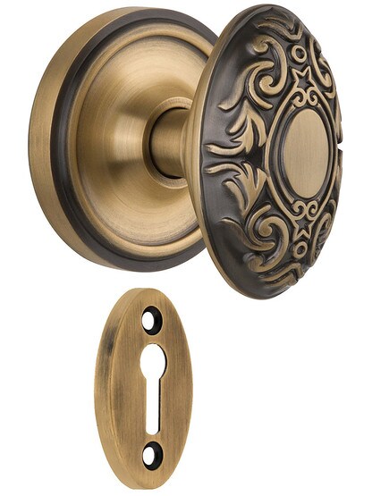 Classic Rosette Mortise Lock Set With Decorative Oval Knobs in Antique Brass.